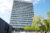 Hochhaus der Hochschule Darmstadt mit markanter Fassade aus dreieckigen Fensterelementen und Bäumen im Vordergrund.