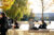 Studierende sitzen auf Bänken im sonnigen Außenbereich des Campus der Hochschule Darmstadt mit Bäumen und modernem Gebäude im Hintergrund.